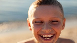 Young boy with braces at beach