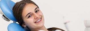 Smiling girl in orthodontic chair