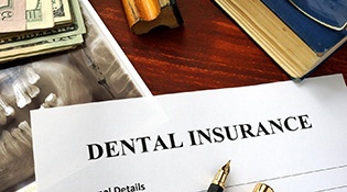Dental insurance form sitting on desk next to X-ray print