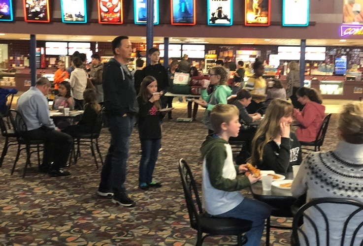Families enjoying food at community Involvement movie theater event