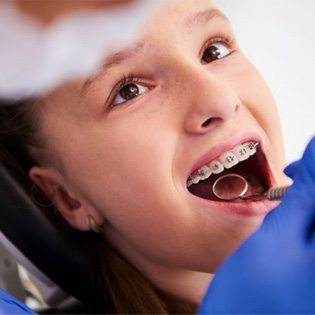 Child with braces undergoing dental exam
