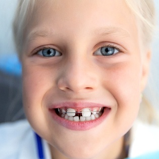 young blonde girl with blue eyes wearing retainer
