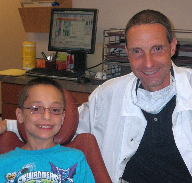 Dr. Cartwright and young boy smiling in exam room