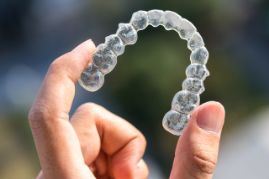 Someone holding a clear aligner tray